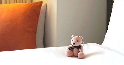신라스테이 곰 인형이 침대 위에 연출된 이미지