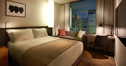 신라스테이 스탠다드 객실 이미지로, 왼쪽에는 침대가, 오른쪽에는 책상 및 소파가 보인다